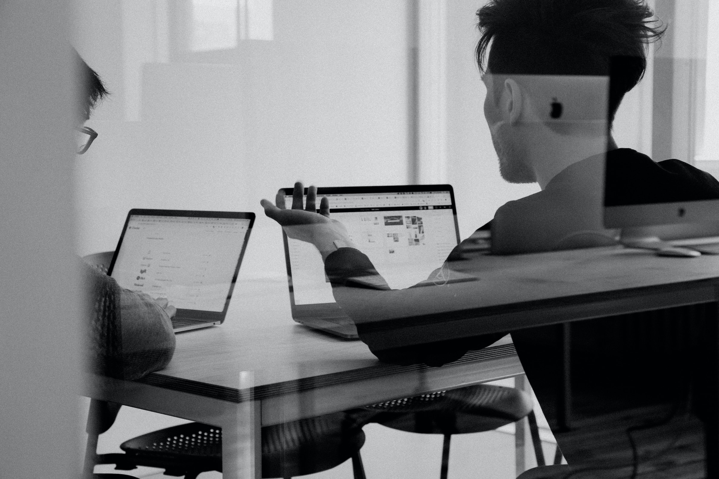 looking at a person through the glass , working on a laptop