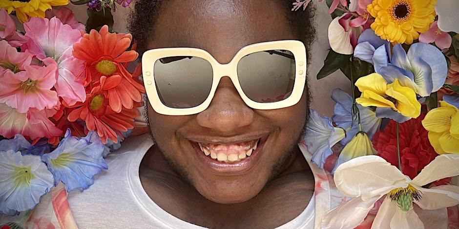 Picture of Brittany Davis face wearing sunglasses surrounded by flowers