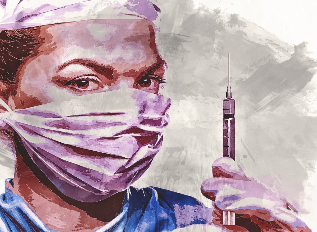 Healthcare Worker wearing a mask and holding a syringe