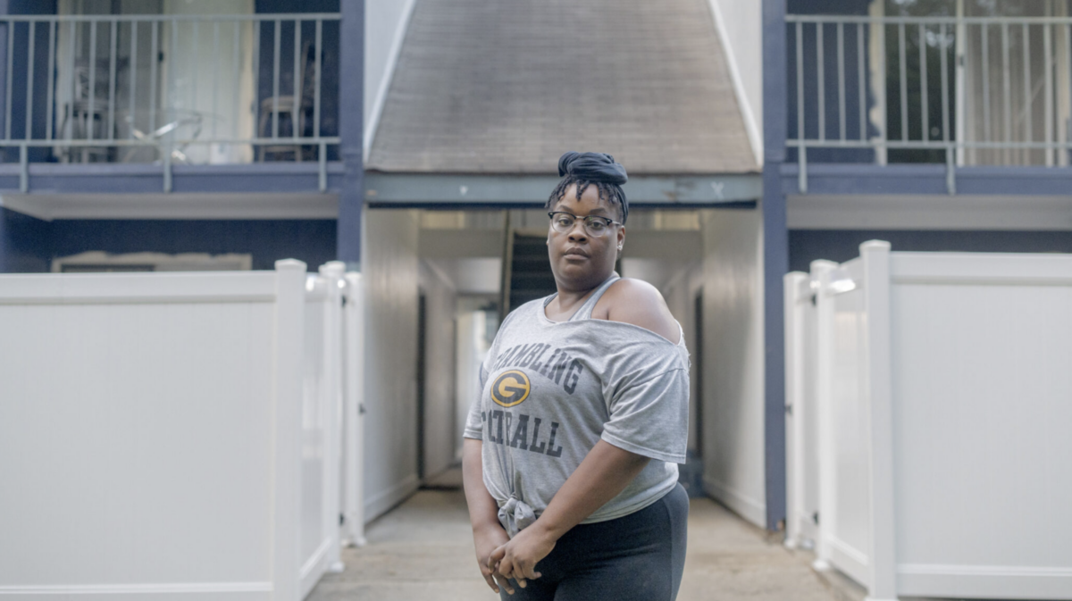 Photo of a black woman named Whitney Carter standing in front of her home in Baton Rouge, Louisiana. Photo by Emily Kask for STAT.