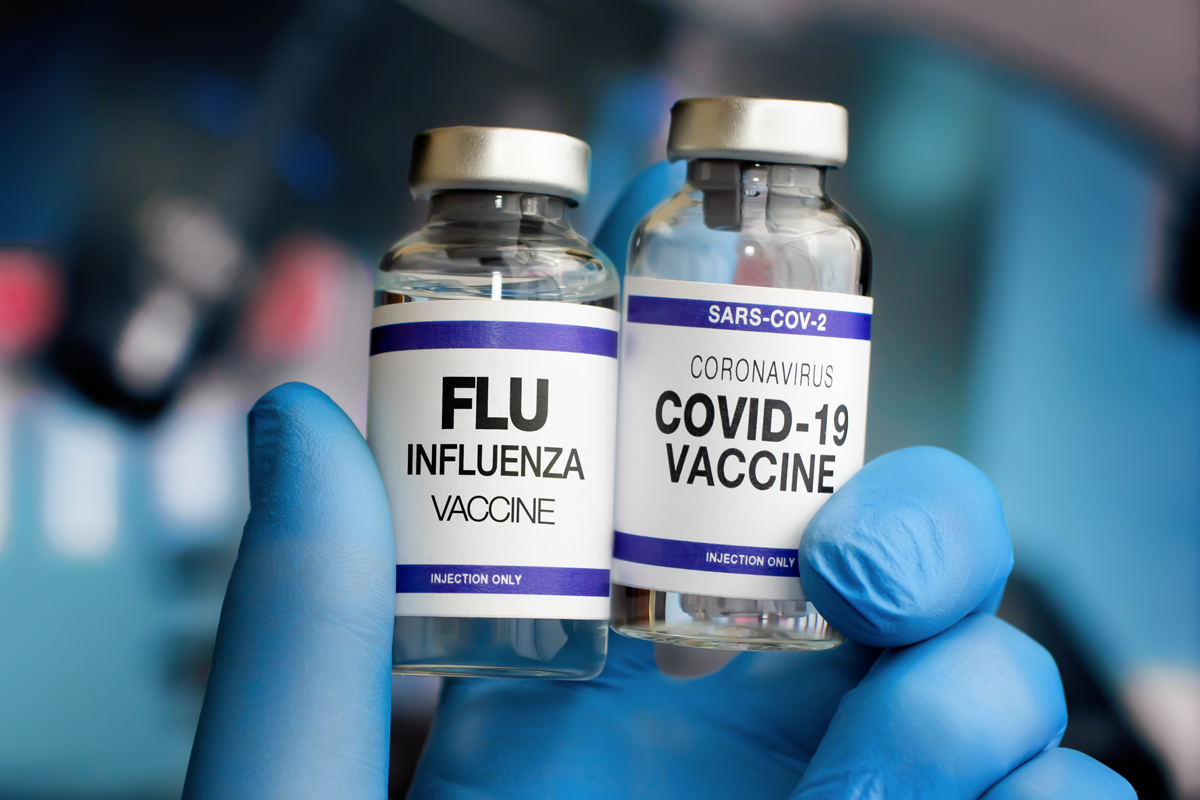 Photo of a person holding Coronavirus vaccine bottles and Flu Shot vaccine for booster vaccination