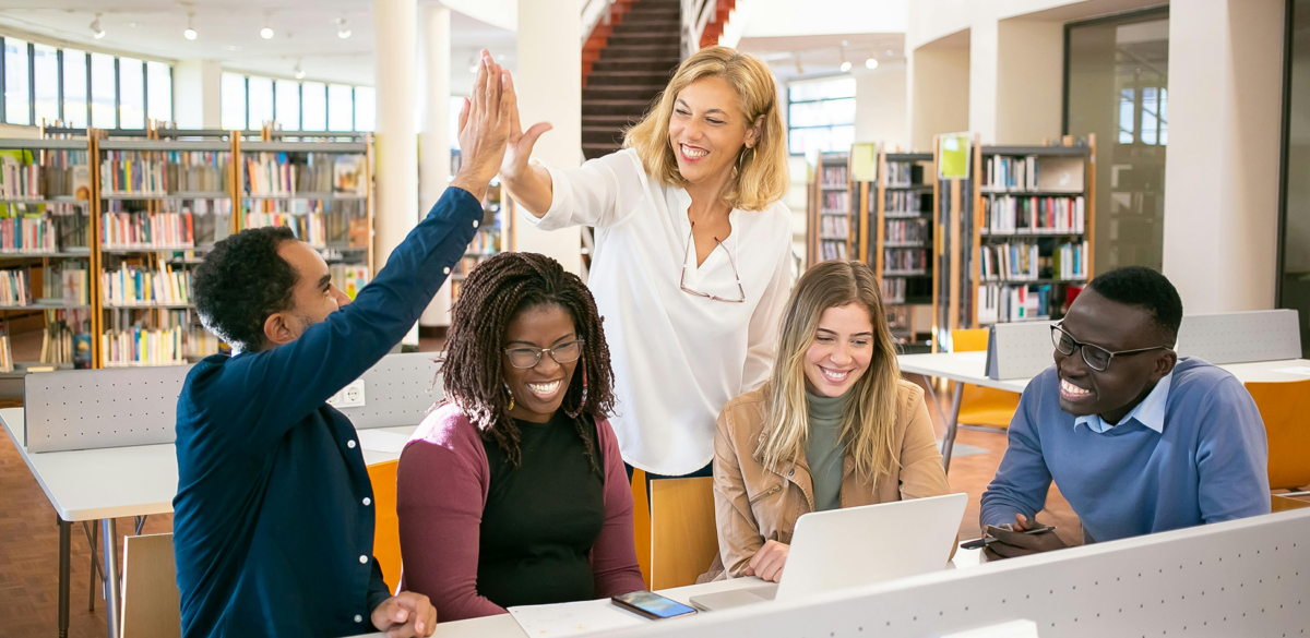 Photo of a team of colleagues - 2 members are high-fiving each other.