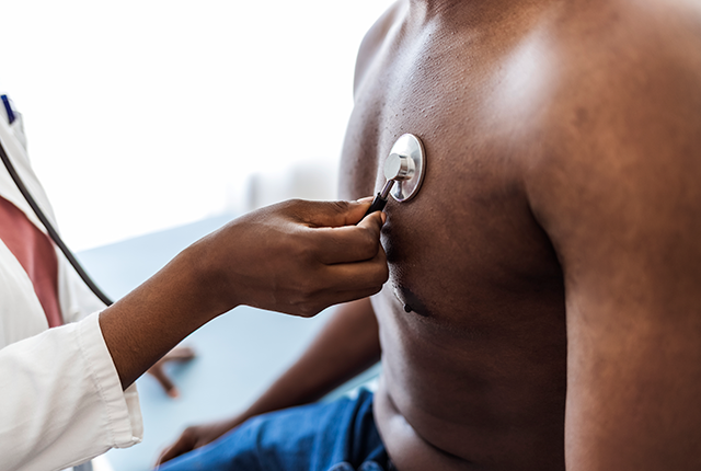 Close up of unrecognizable doctor listening to a heartbeat of her black male patient with stethoscope.